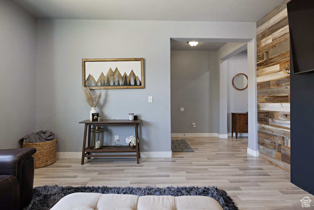 Interior space featuring baseboards, wood walls, and light wood finished floors