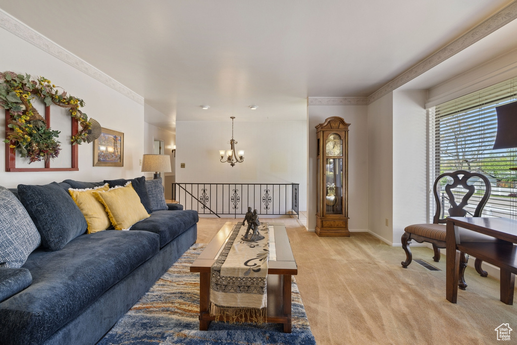 Living room featuring light colored carpet, baseboards, and a chandelier