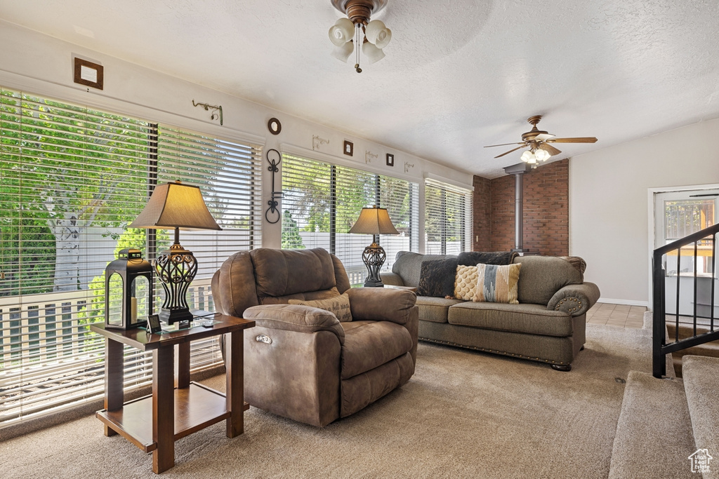 Living area featuring carpet floors, a ceiling fan, and a wealth of natural light