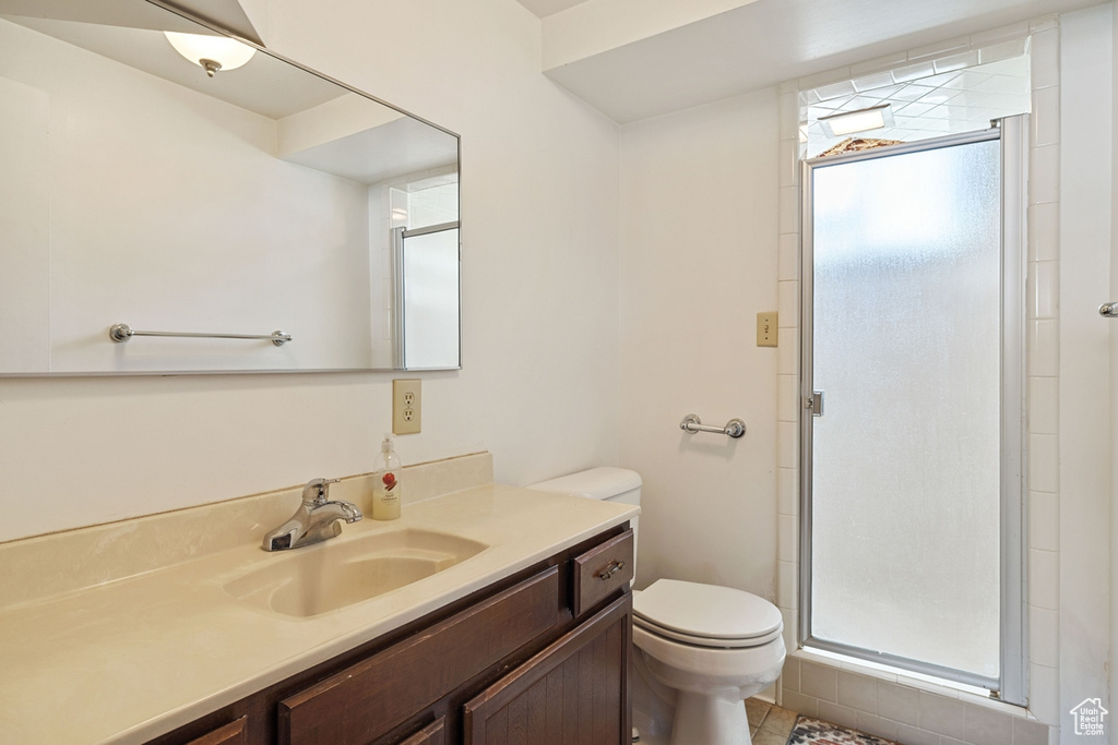 Bathroom featuring vanity, a shower stall, and toilet