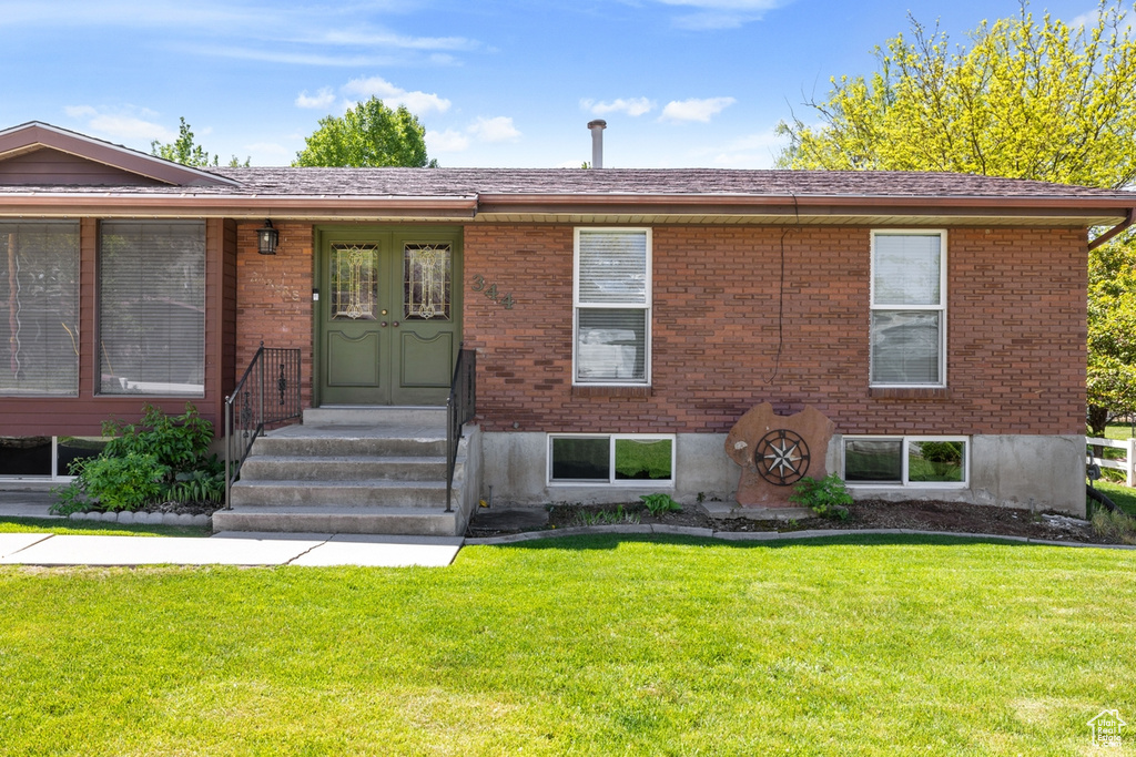 View of front of house with brick siding and a front lawn