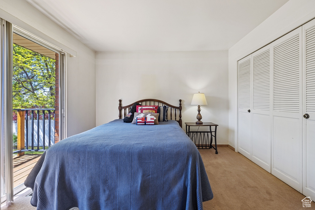 Carpeted bedroom with a closet and access to exterior