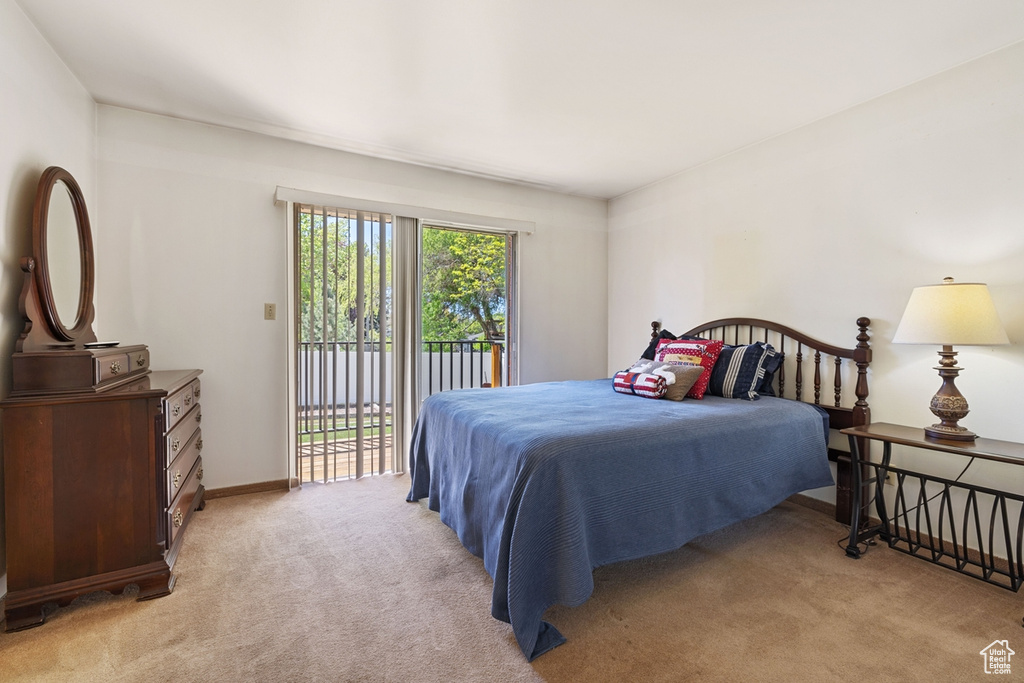 Carpeted bedroom featuring baseboards and access to exterior