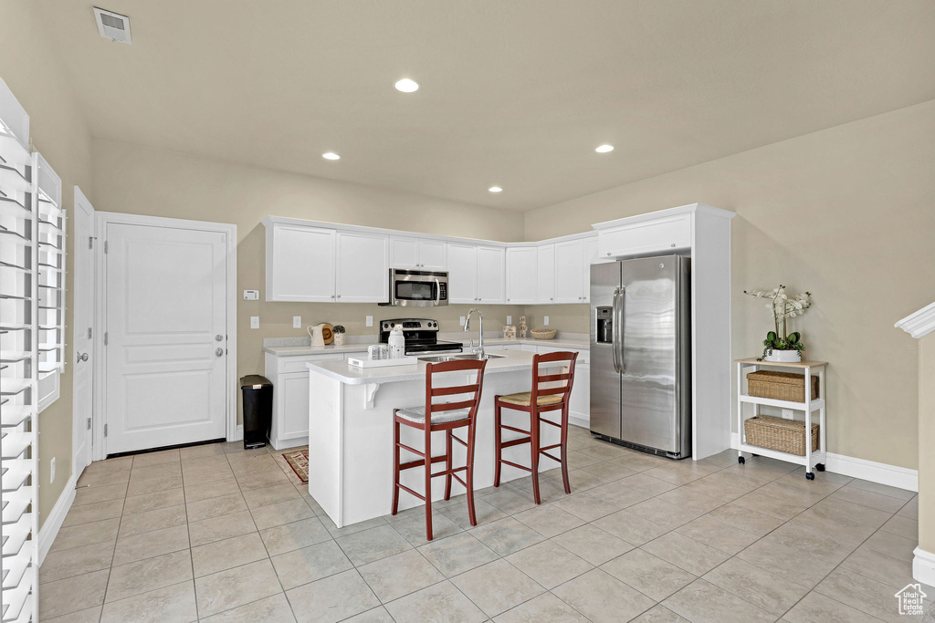 Kitchen with visible vents, appliances with stainless steel finishes, light countertops, light tile patterned floors, and a sink