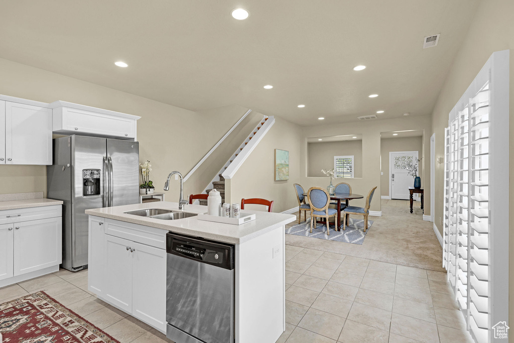 Kitchen with a sink, appliances with stainless steel finishes, light tile patterned floors, and recessed lighting