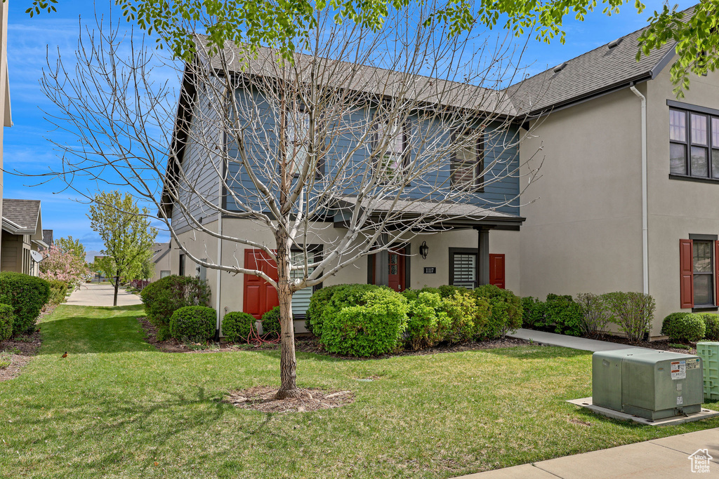 Traditional-style house with stucco siding and a front yard