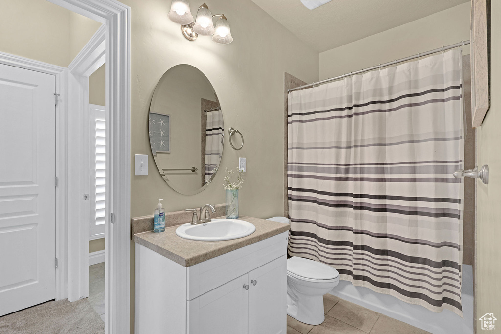 Bathroom with vanity, tile patterned floors, shower / bath combo, and toilet