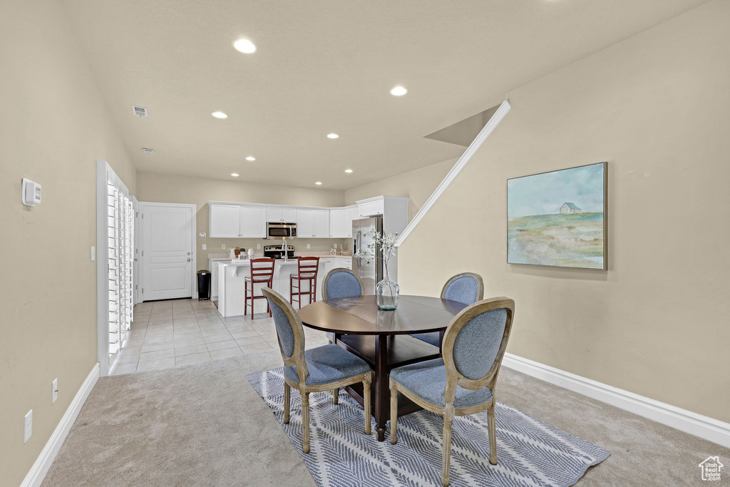 Dining room with baseboards, recessed lighting, and light carpet