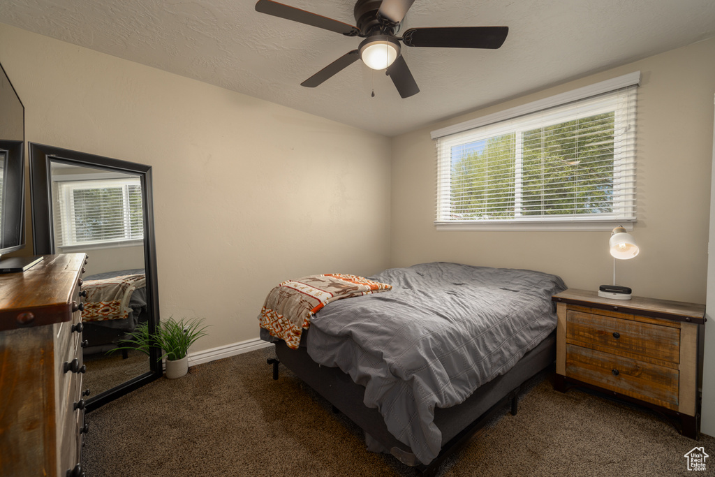 Carpeted bedroom featuring baseboards and a ceiling fan