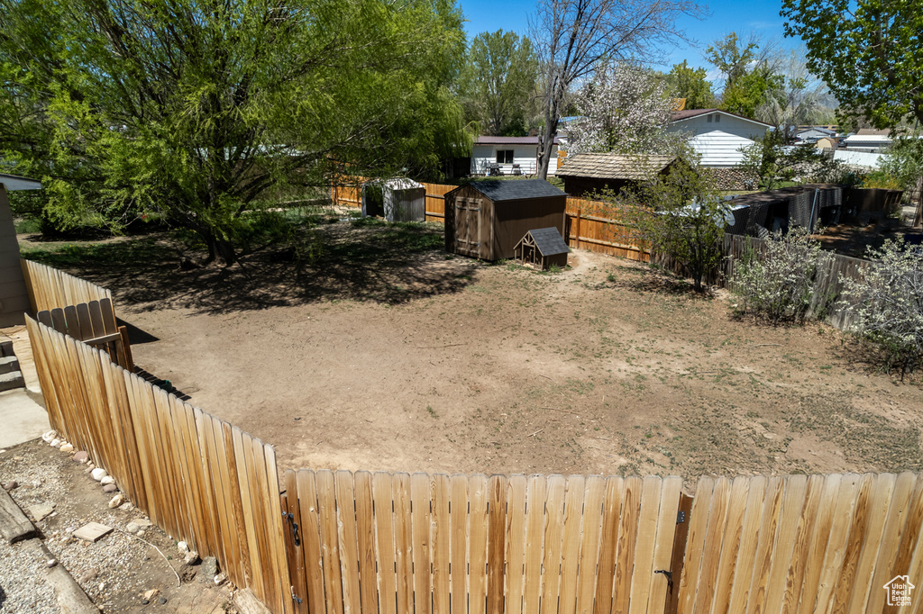 View of yard with a fenced backyard and a shed