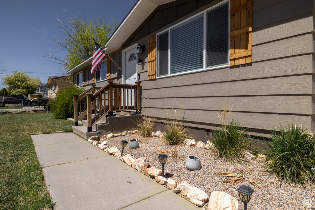 View of side of home featuring fence and a lawn