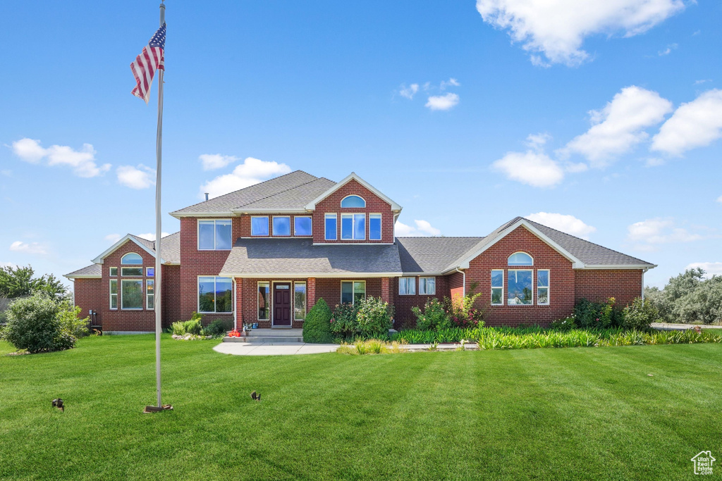 View of front of home with a front yard and brick siding