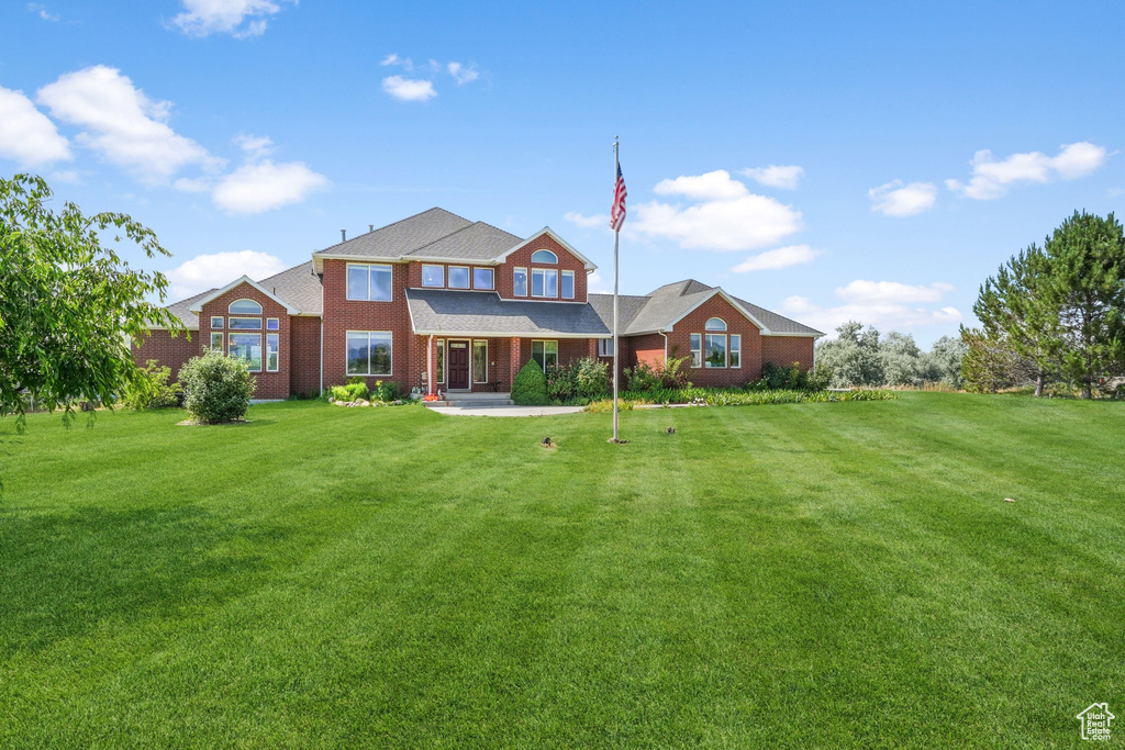 Back of property with a yard and brick siding