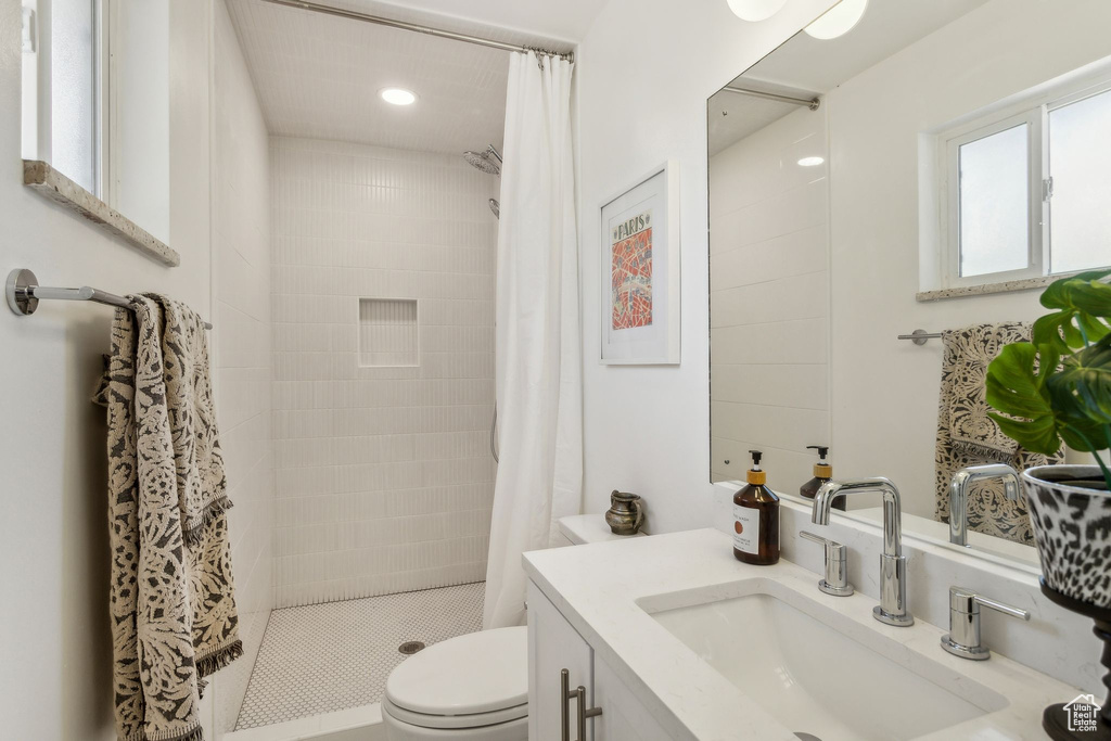 Bathroom with vanity, toilet, recessed lighting, and a stall shower