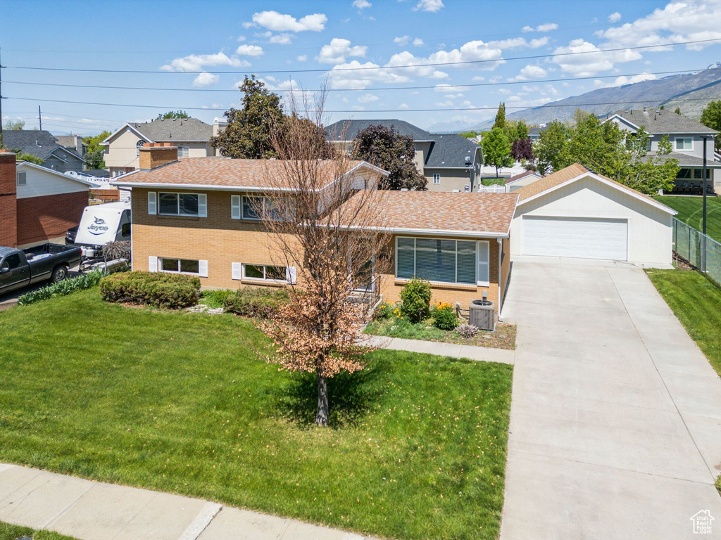 View of front of home with a front lawn, a mountain view, a residential view, and cooling unit