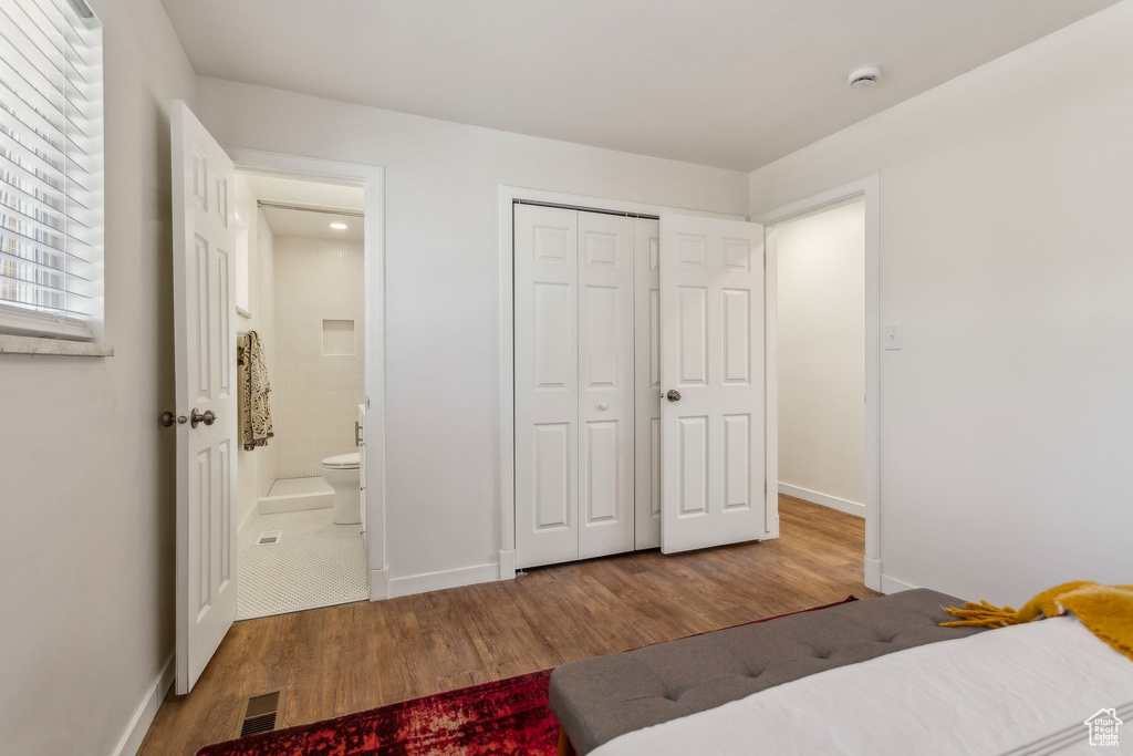 Bedroom with visible vents, baseboards, and wood finished floors