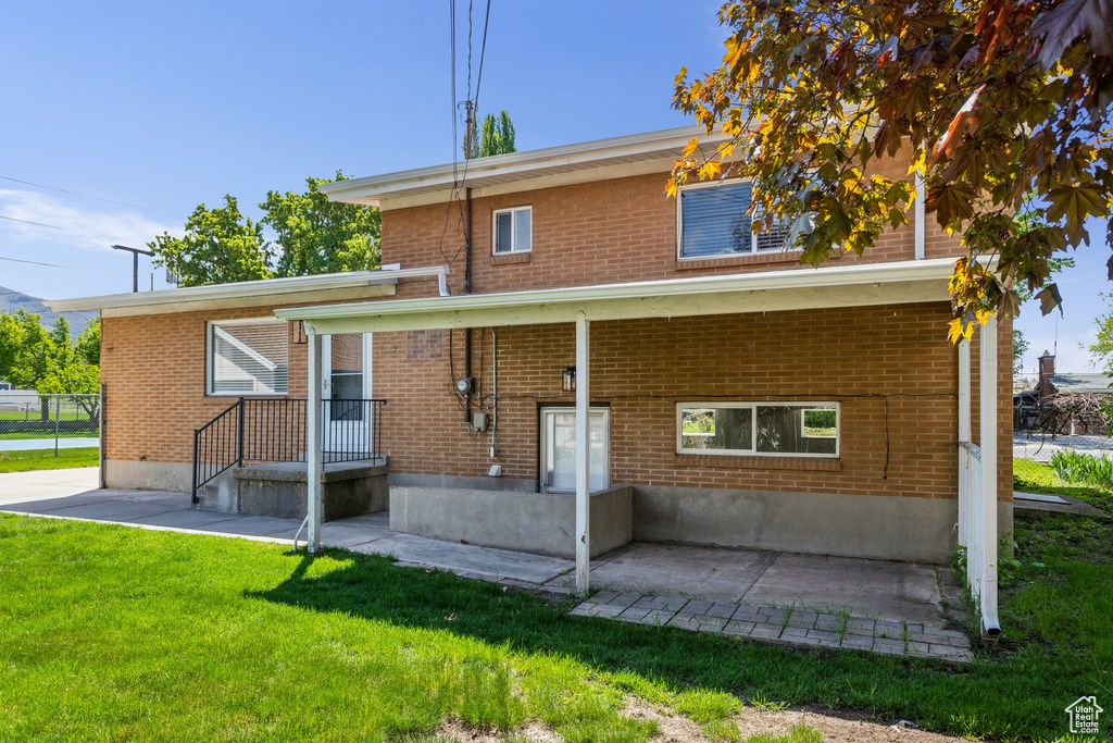 Back of property featuring a yard and brick siding