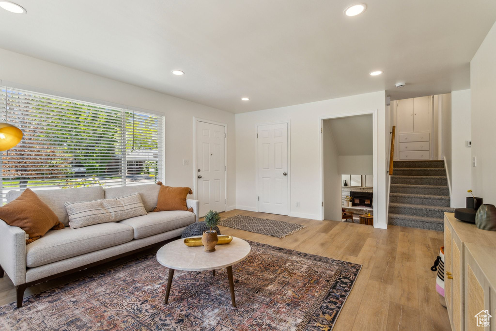 Living area featuring recessed lighting, light wood-style flooring, stairs, and baseboards