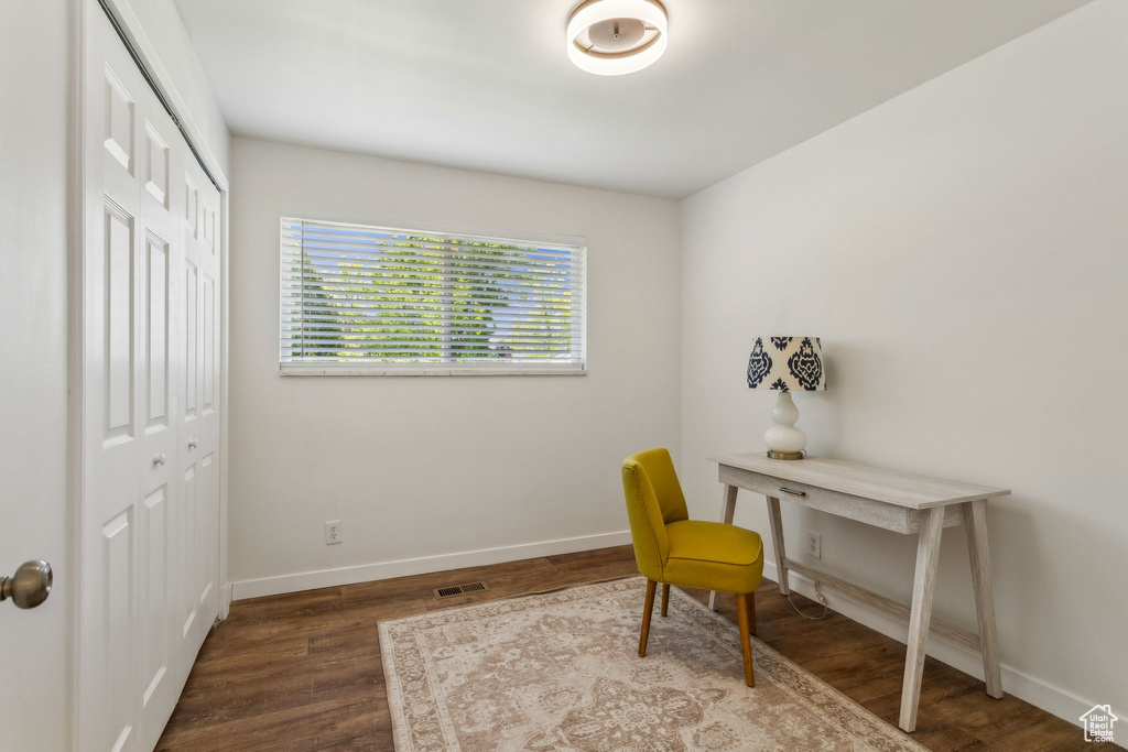 Office area with visible vents, baseboards, and dark wood-type flooring