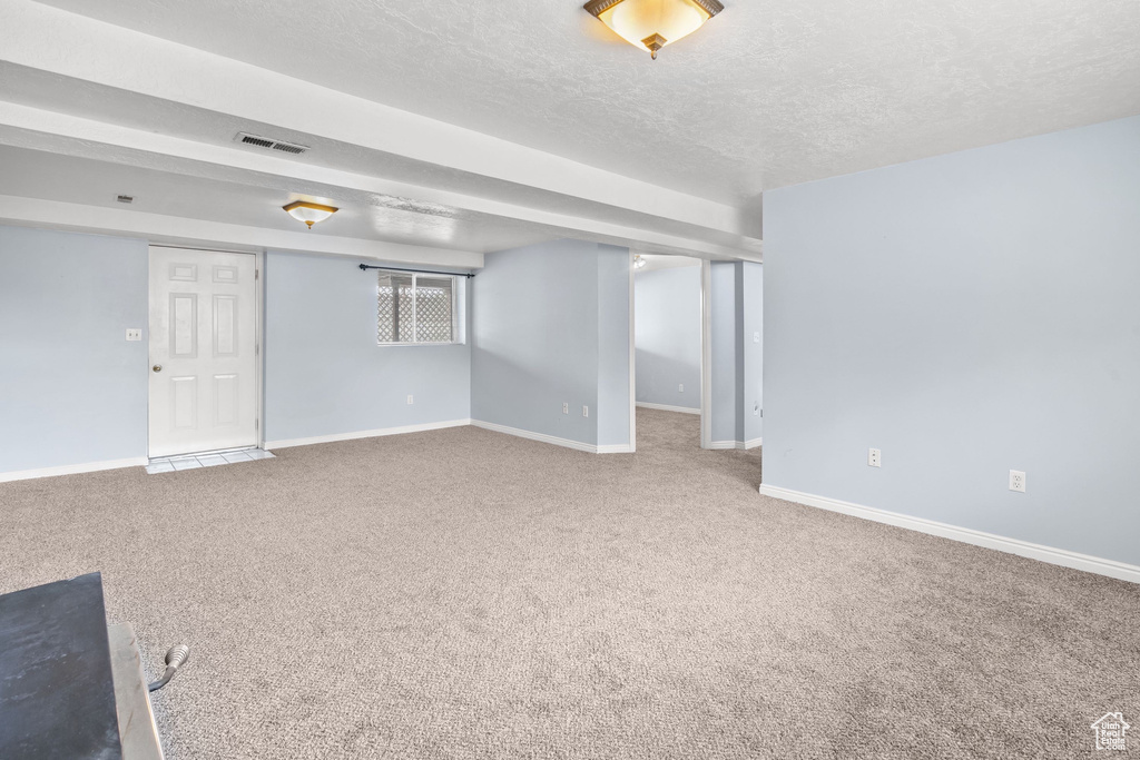 Interior space featuring visible vents, a textured ceiling, and baseboards