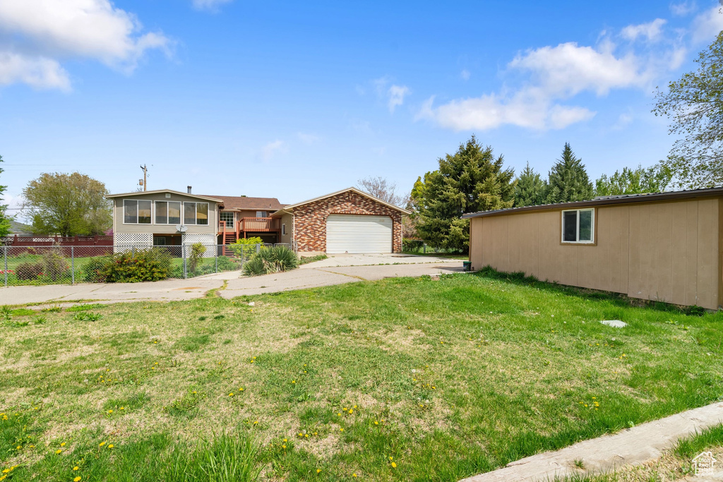 View of front of home with fence, brick siding, a garage, a front yard, and concrete driveway