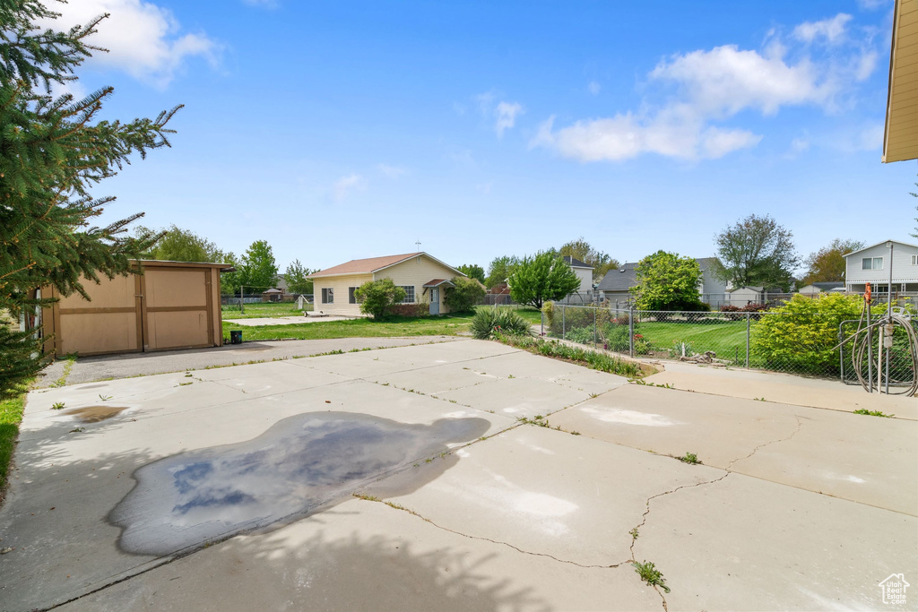 Exterior space with fence, a front lawn, a shed, a patio area, and an outdoor structure