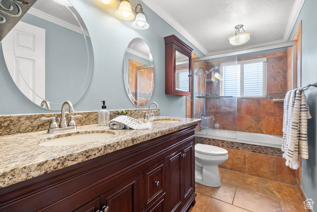 Bathroom featuring a sink, tile patterned floors, toilet, and tiled shower / bath combo
