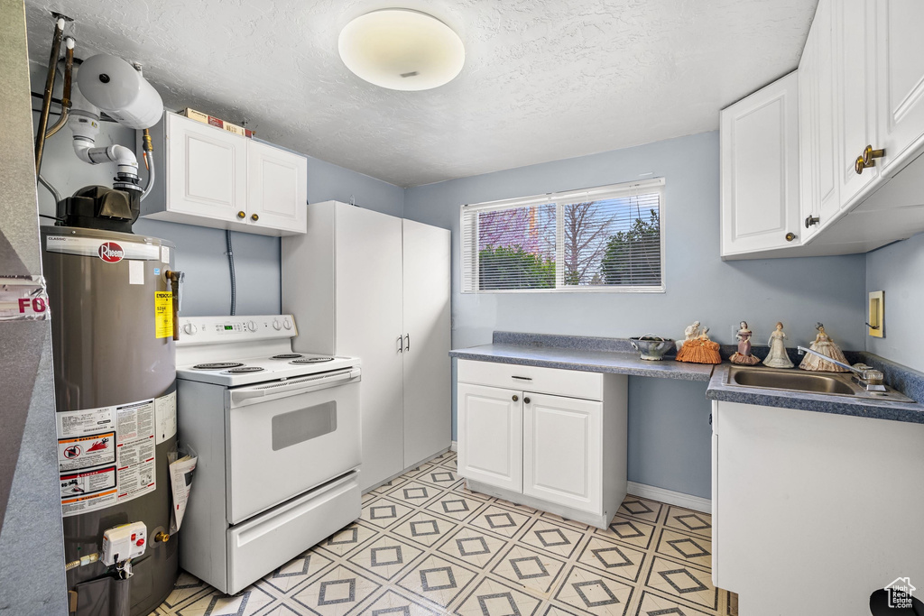 Kitchen featuring white cabinets, a textured ceiling, gas water heater, and white electric range