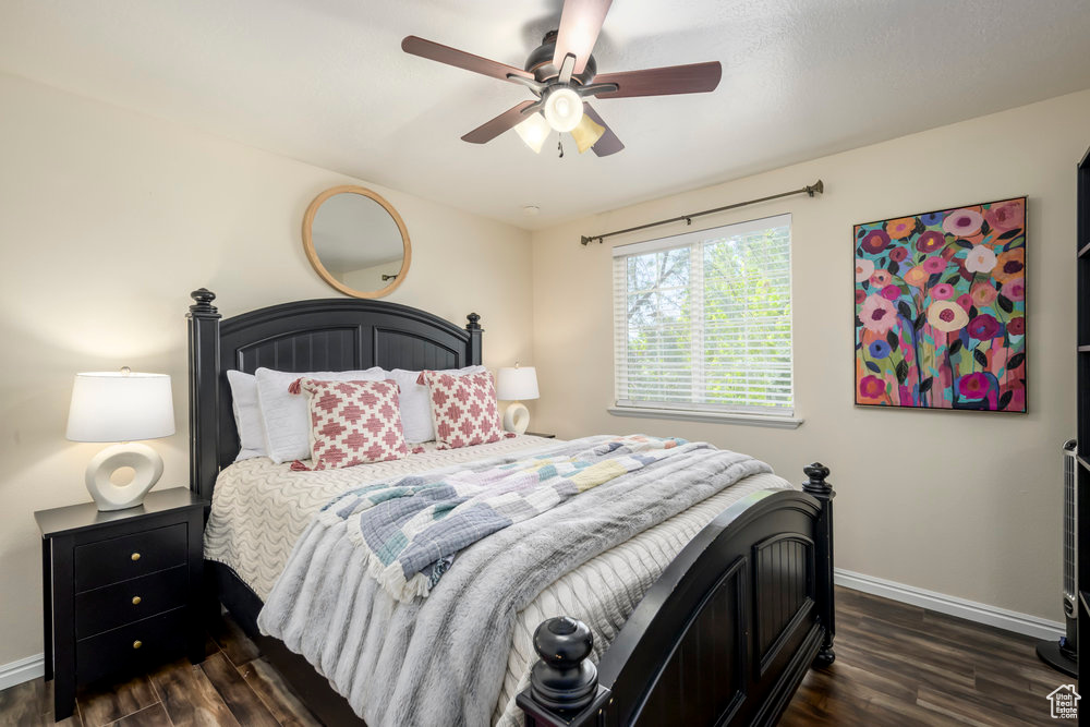 Bedroom with baseboards, a ceiling fan, and dark wood-style floors