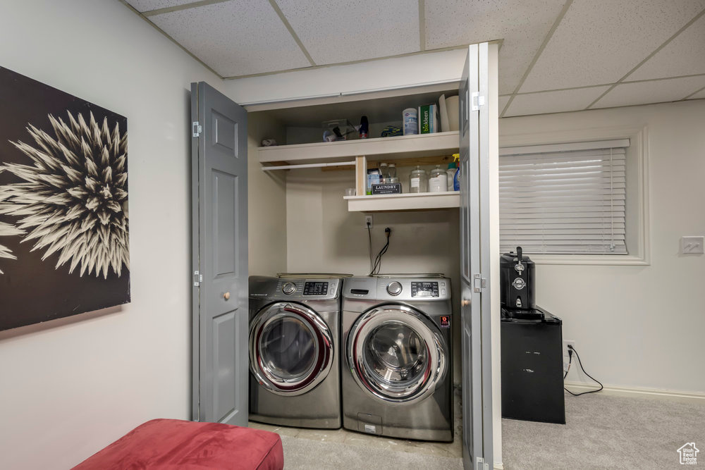 Washroom featuring laundry area, washer and clothes dryer, baseboards, and carpet floors