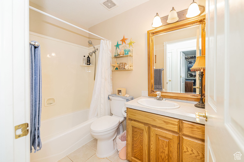 Bathroom with vanity, toilet, tile patterned floors, shower / bath combination with curtain, and visible vents