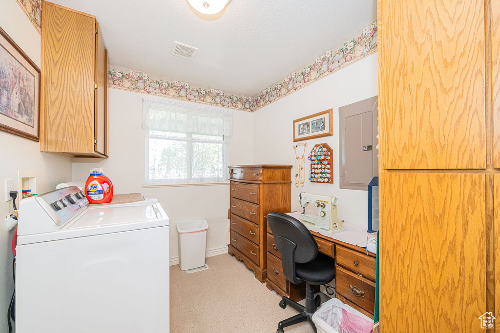 Home office featuring washing machine and clothes dryer, visible vents, light carpet, and electric panel