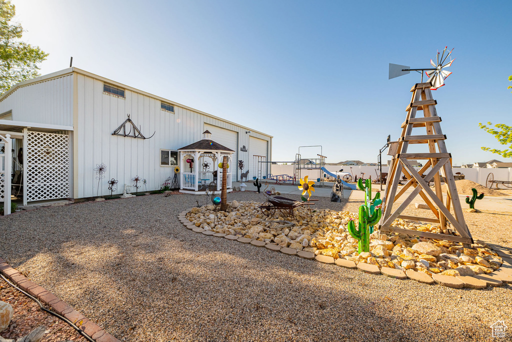 View of front facade featuring a playground and board and batten siding