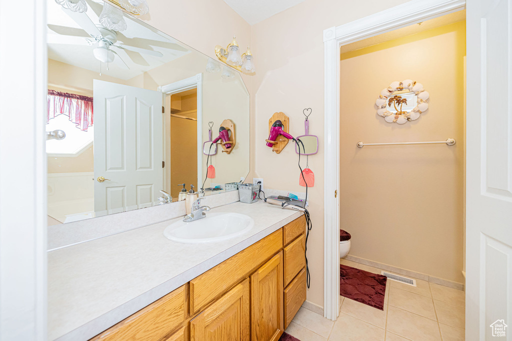 Full bathroom featuring a ceiling fan, visible vents, vanity, tile patterned floors, and toilet