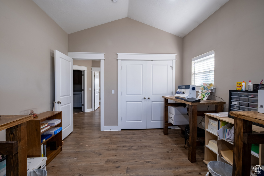 Home office with vaulted ceiling and wood finished floors