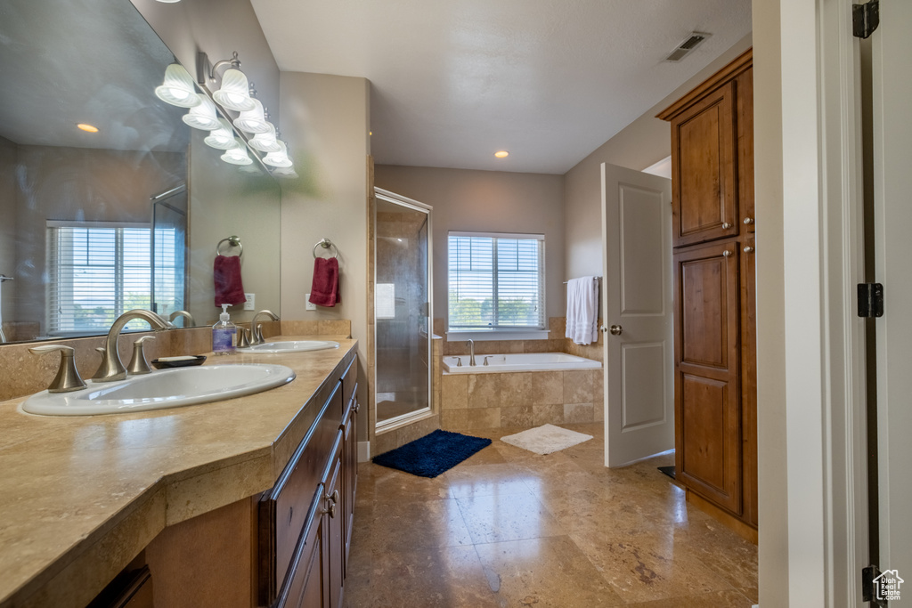 Full bathroom featuring a bath, a stall shower, double vanity, and recessed lighting