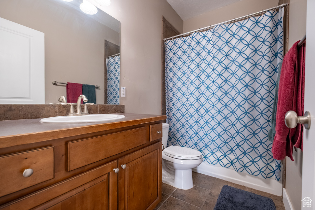 Full bath featuring vanity, toilet, and tile patterned flooring