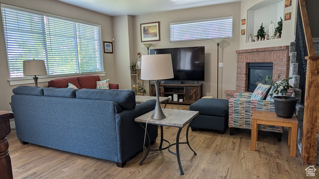 Living area featuring light wood finished floors and a brick fireplace