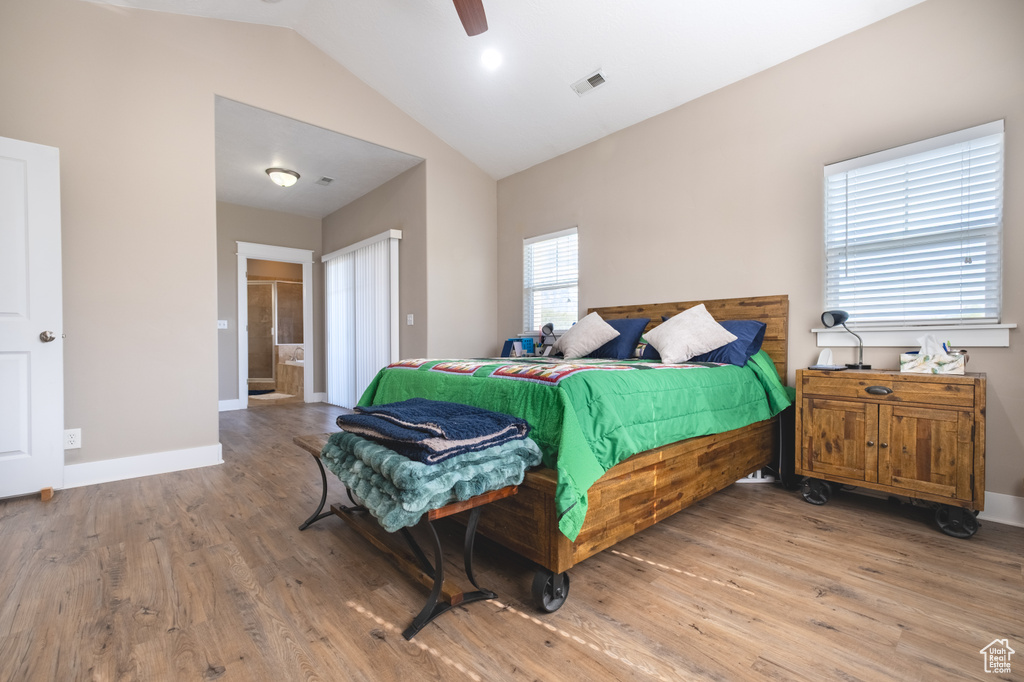 Bedroom featuring wood finished floors, baseboards, ensuite bath, ceiling fan, and high vaulted ceiling