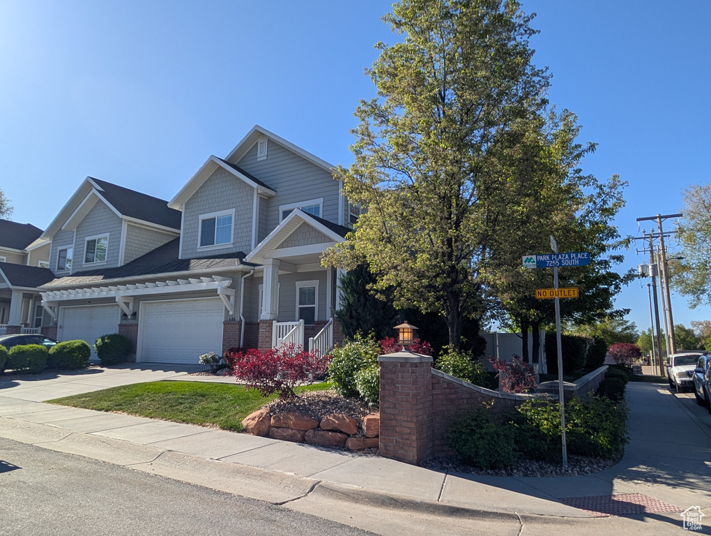 Craftsman inspired home featuring brick siding, a garage, and concrete driveway