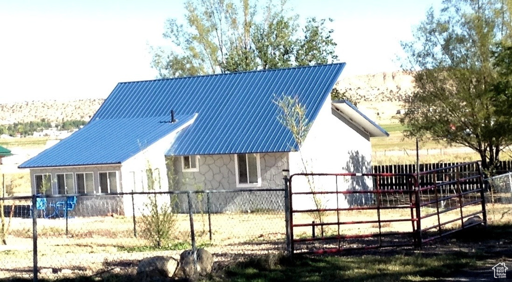 Exterior space featuring a fenced front yard, stone siding, and metal roof