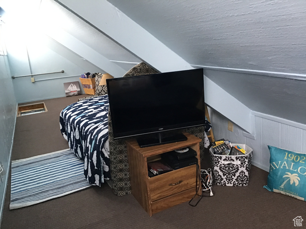 Bedroom with vaulted ceiling and carpet flooring
