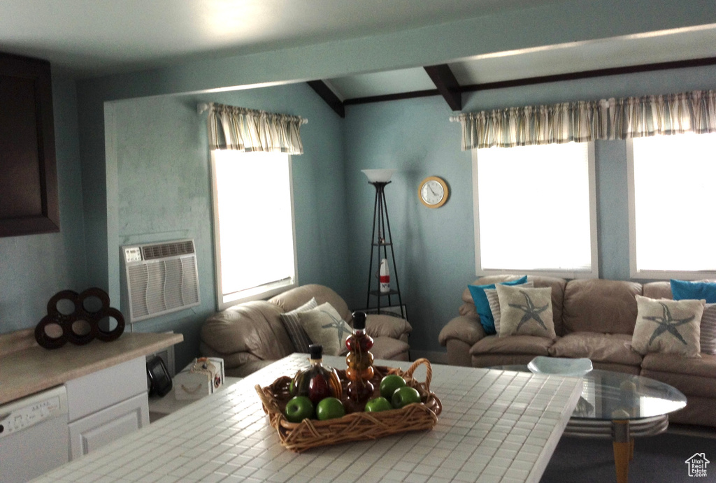 Living area featuring plenty of natural light, lofted ceiling with beams, and cooling unit