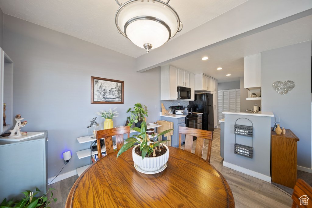 Dining space with baseboards, recessed lighting, and light wood-style flooring