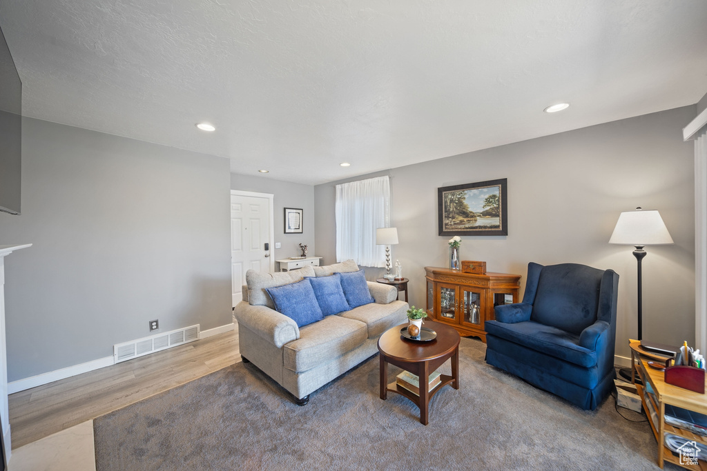 Living room featuring visible vents, recessed lighting, baseboards, and wood finished floors