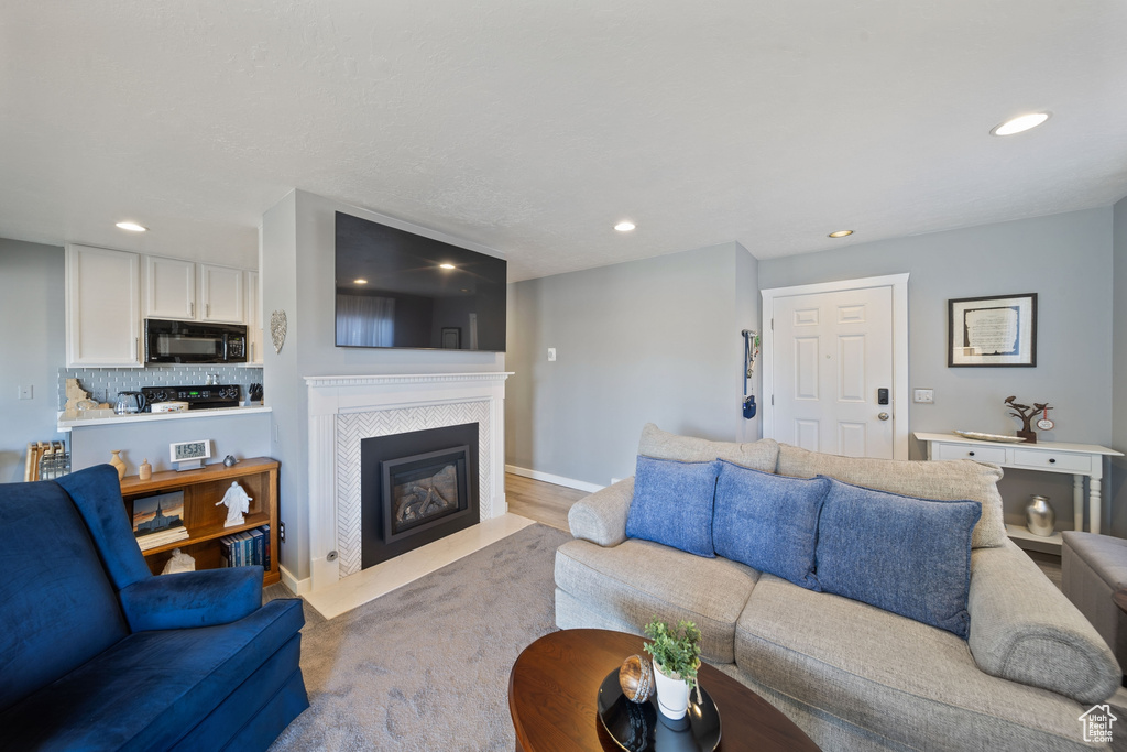 Living room with baseboards, recessed lighting, and a tile fireplace