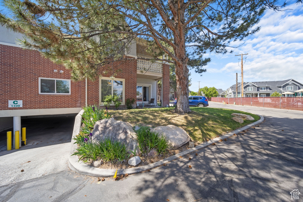 View of front of house featuring brick siding, fence, and a residential view