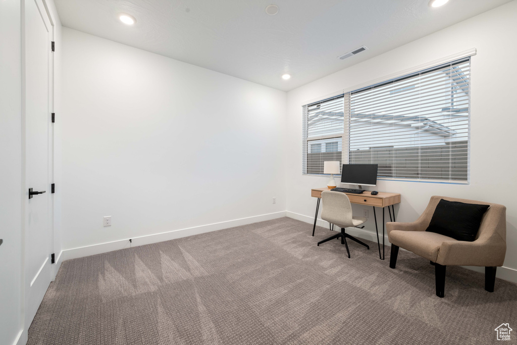 Carpeted office space featuring baseboards, recessed lighting, and visible vents