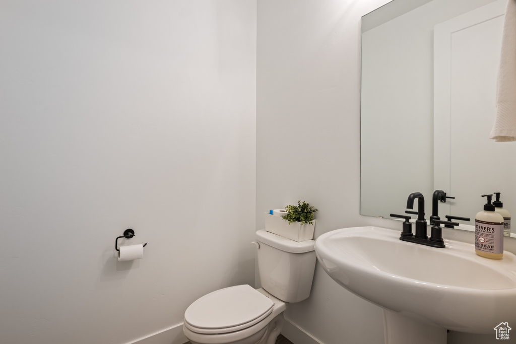 Bathroom with baseboards, a sink, and toilet