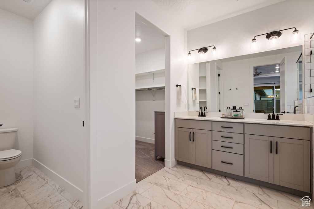 Full bath with toilet, baseboards, a sink, and marble finish floor